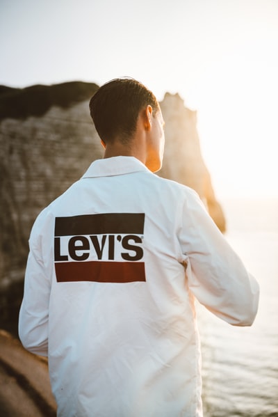 海滩上穿着白色Levi's衬衫的男子